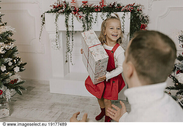 Smiling daughter holding christmas present