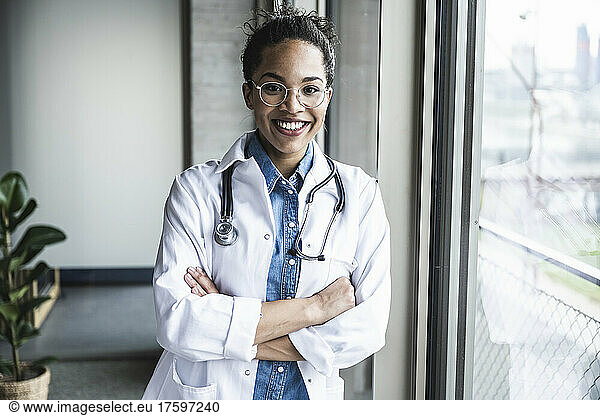 Smiling doctor with arms crossed in clinic