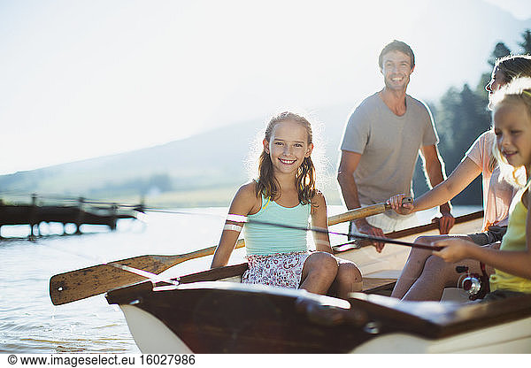 Smiling family in rowboat on lake