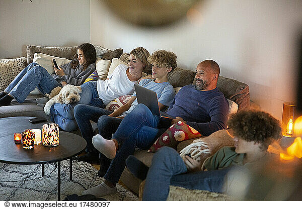 Smiling family sitting on sofa in living room at home