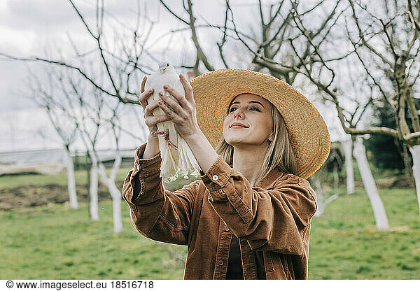 Smiling farmer holding dove in garden