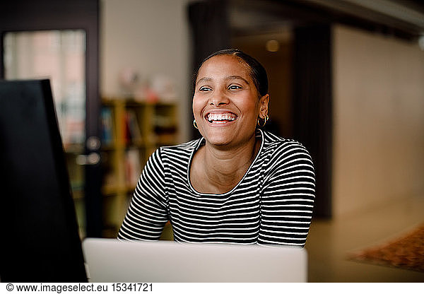 Smiling female entrepreneur looking away in office