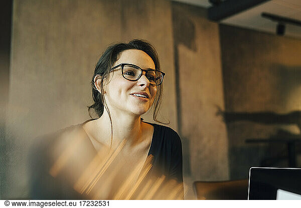 Smiling female entrepreneur looking away in office