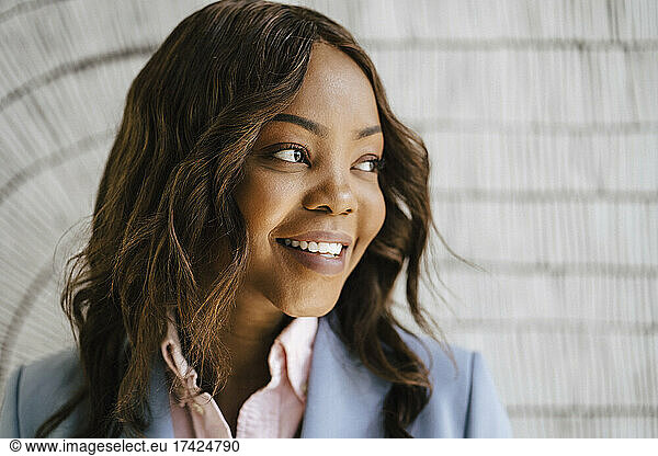 Smiling female entrepreneur with brown hair looking away