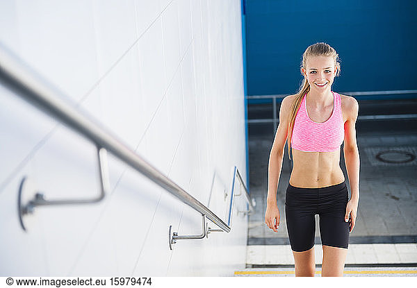 Smiling female jogger on stairs