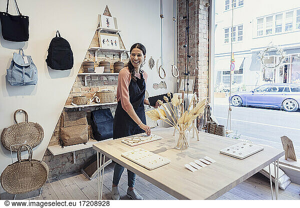Smiling female owner with digital tablet looking away in design studio