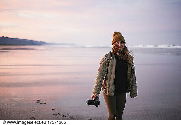 Smiling Female Photographer alone on Oregon beach at sunrise