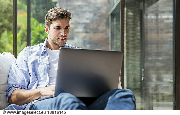 Smiling freelancer working on laptop at home