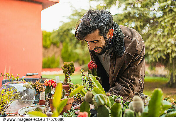 smiling gardener checking the condition and growth of plants
