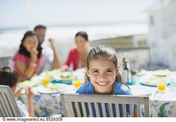 Smiling girl at table on sunny patio