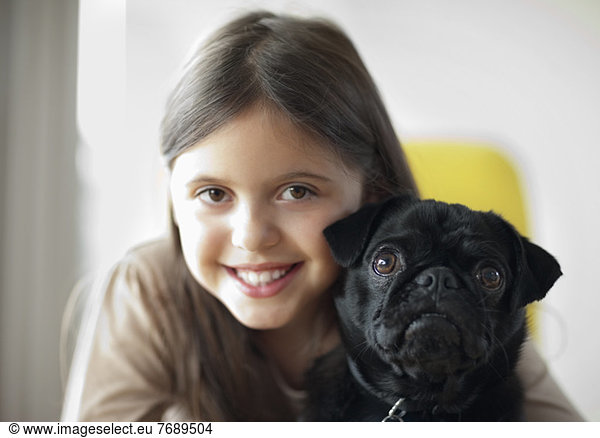 Smiling girl holding dog