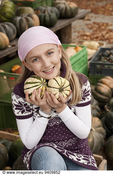 Smiling girl holding squashes