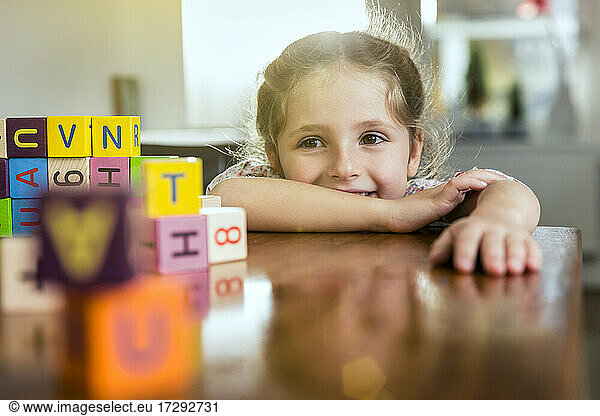 Smiling girl leaning on table at home