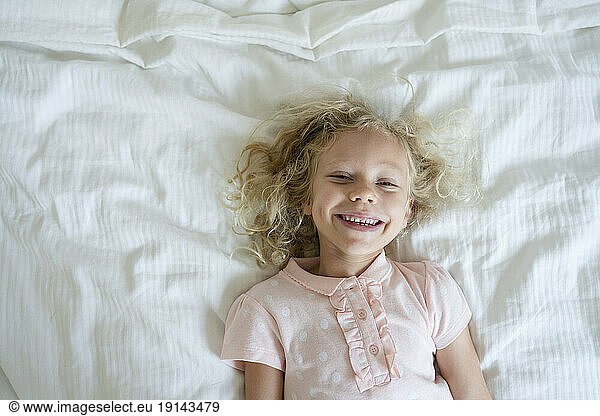 Smiling girl relaxing on bed at home
