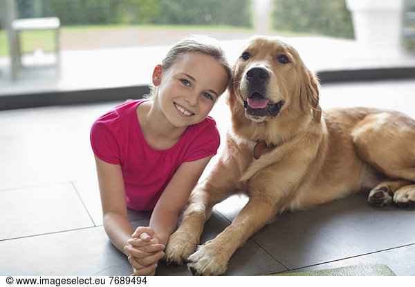 Smiling girl relaxing with dog indoors