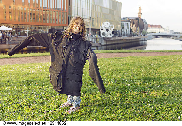 Smiling girl (4-5) wearing oversized jacket