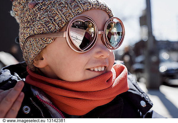Smiling girl wearing sunglasses and warm clothing