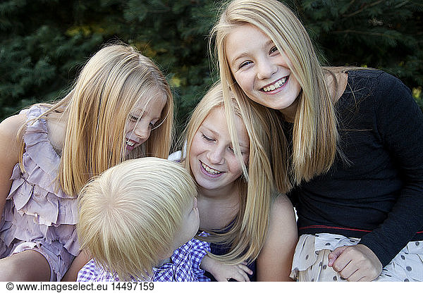 Smiling Girls Looking at Young Boy