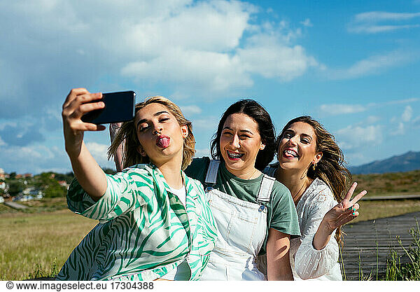 Smiling girls taking a selfie together outdoors