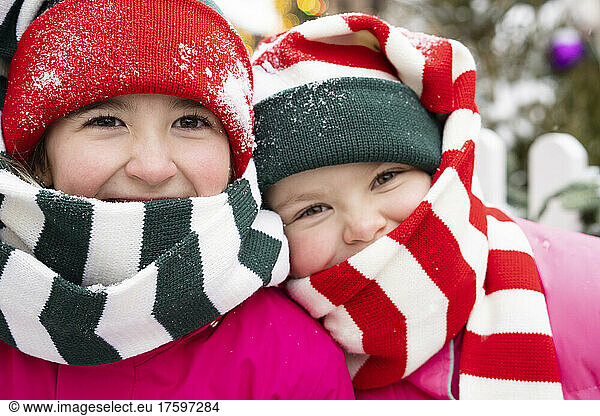 Smiling girls wearing knit hat and scarf in winter