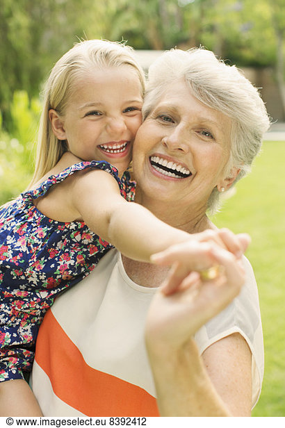 Smiling grandmother holding granddaughter