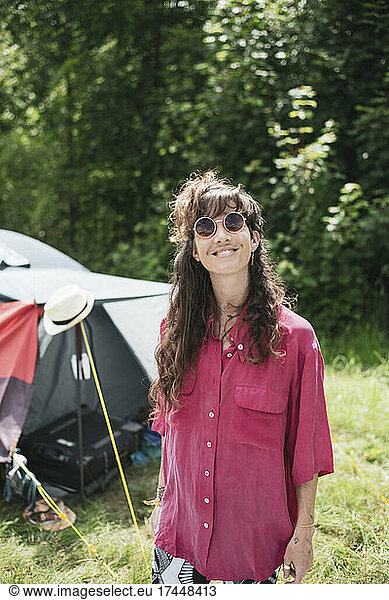 Smiling happy beautiful woman with long brown hair pink shirt camping