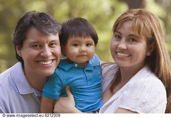 Smiling Hispanic parents holding baby boy