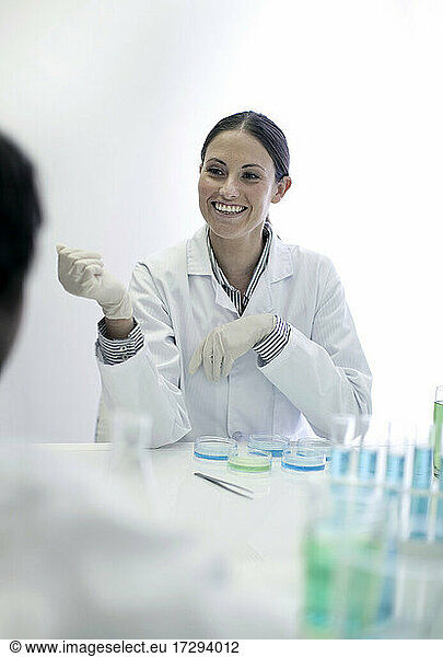 Smiling lab technician working with colleague in laboratory