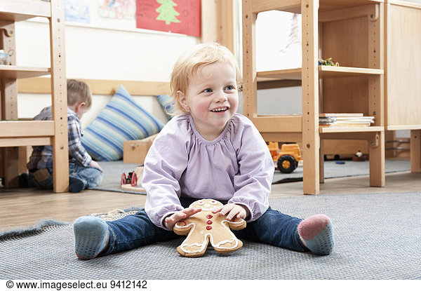 Smiling little girl holding gingerbread man
