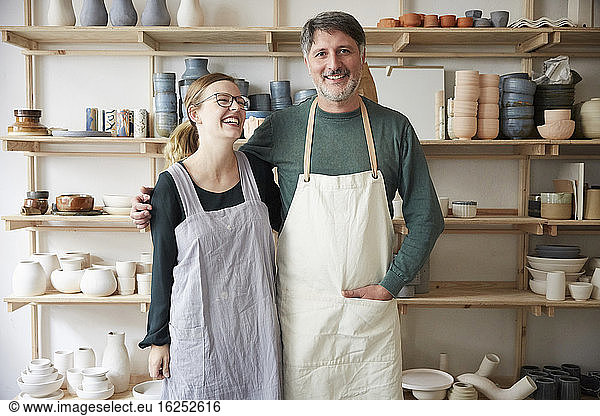 Smiling male and female coworkers in art studio