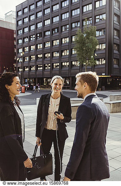 Smiling male and female entrepreneurs standing outdoors