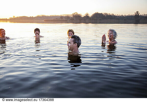 Smiling male and female friends enjoying in cold water