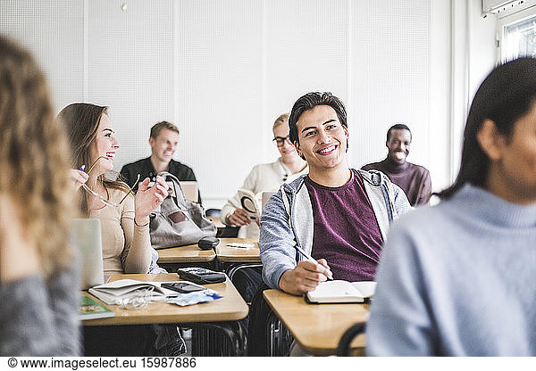 Smiling male and female students in classroom at university