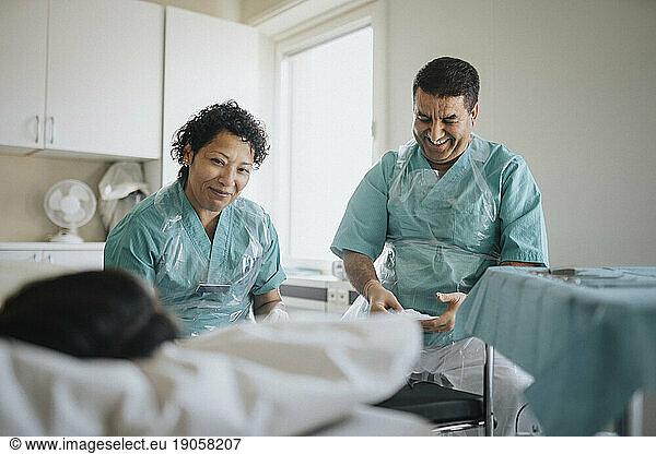 Smiling male and female surgeons with young patient in hospital