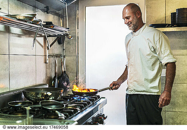 Smiling male chef cooking in restaurant