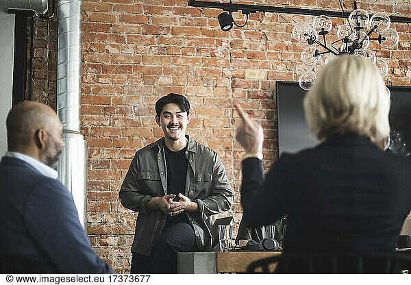 Smiling male entrepreneur presenting idea in office