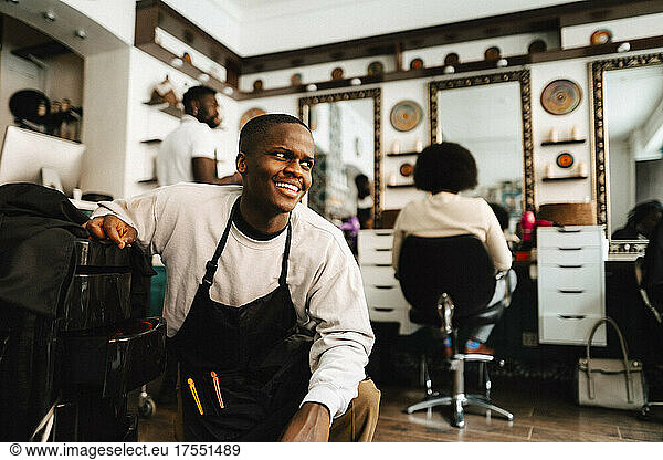 Smiling male hairdresser looking away in barber shop
