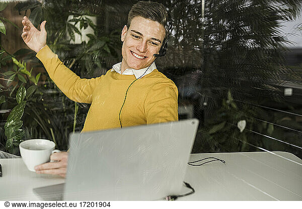 Smiling male professional gesturing while talking through video conference