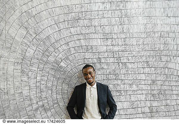 Smiling male professional standing in front of wall at convention center