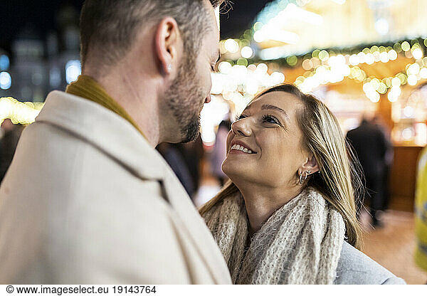 Smiling man and woman enjoying at Christmas market