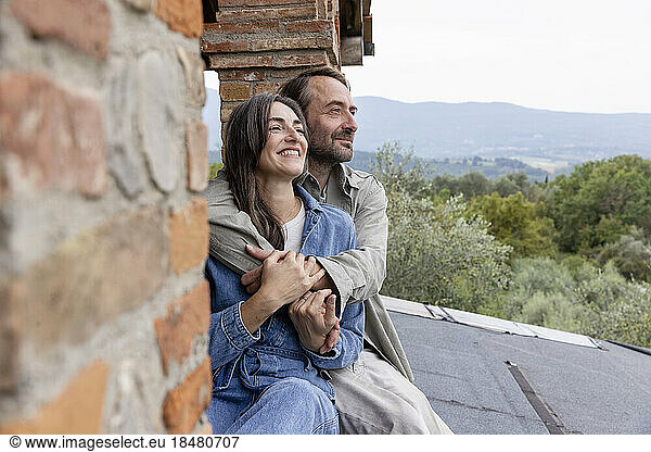 Smiling man and woman sitting on rooftop