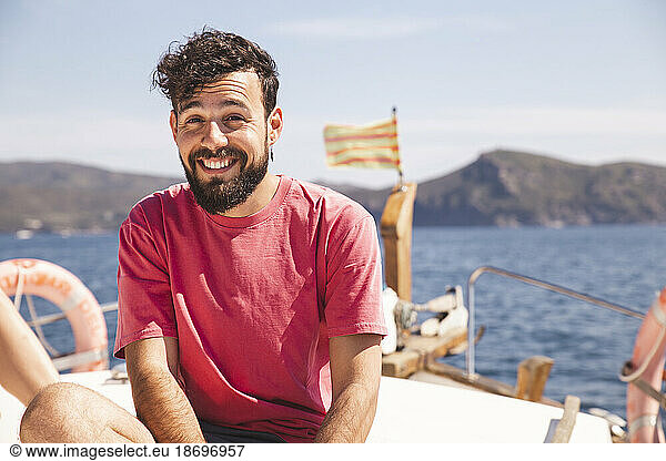 Smiling man enjoying vacation on yacht at sunny day