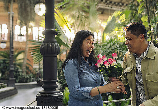Smiling man giving flowers to woman on Valentine's Day
