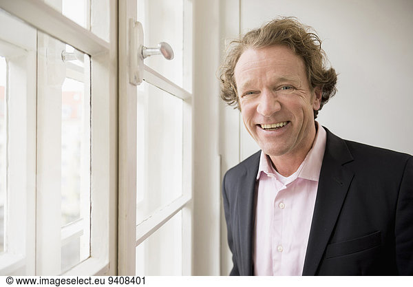 Smiling man in suit at the window