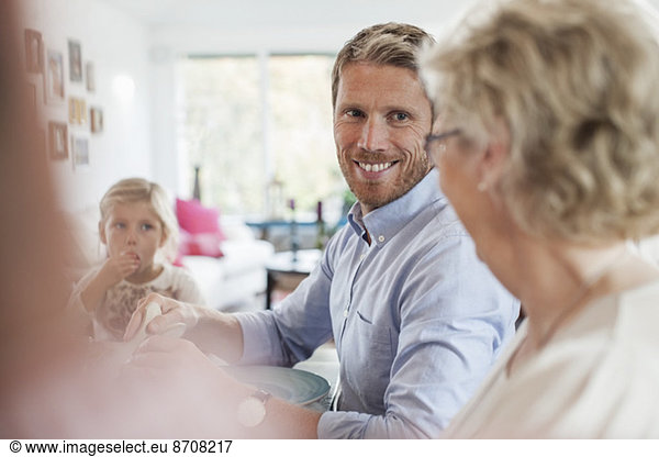 Smiling man looking at mother during lunch