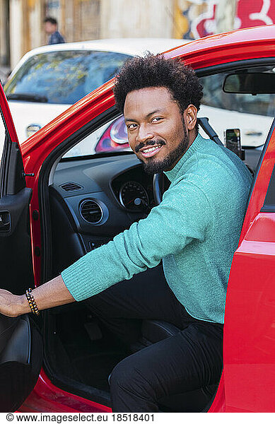 Smiling man opening car door
