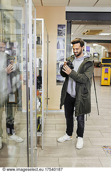 Smiling man shopping camera in store