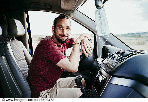 Smiling man sitting in car during COVID-19
