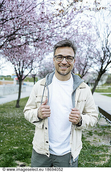 Smiling man wearing eyeglasses standing at park