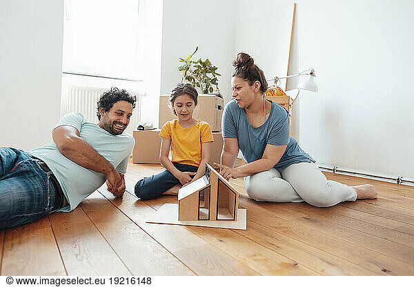 Smiling man with woman and daughter looking at model house
